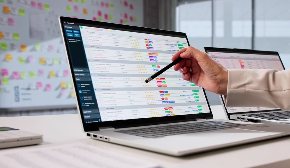 An accountant reviewing financial data on a laptop screen with charts and spreadsheets, analysing performance for a company in a modern office setting