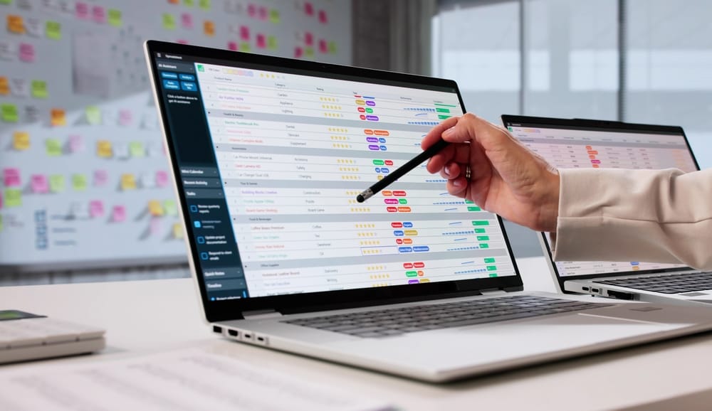 An accountant reviewing financial data on a laptop screen with charts and spreadsheets, analysing performance for a company in a modern office setting