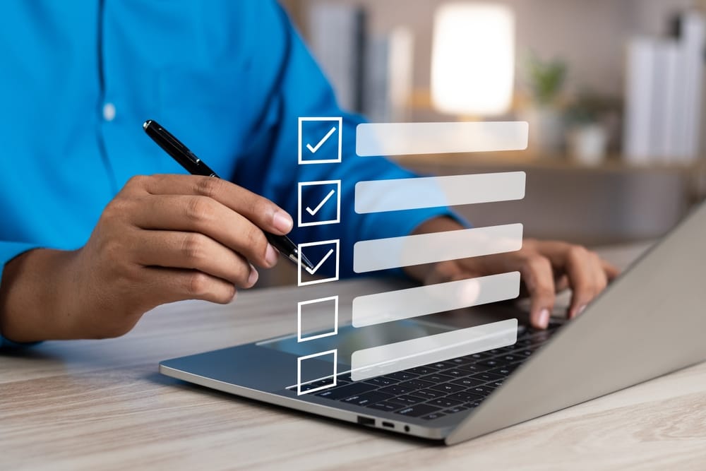 Person reviewing a starting a company checklist on a laptop, with checkboxes representing key business setup tasks.